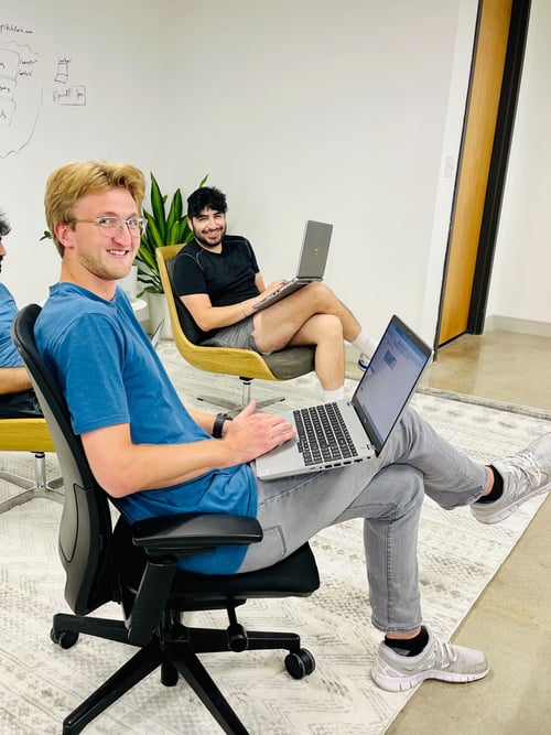 Striveworks team members work on their laptops in an open area