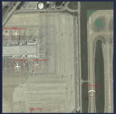 An aerial shot of an airport with airplanes detected by machine learning