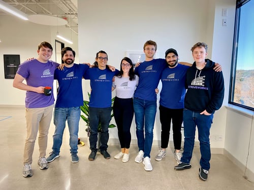 Striveworks team members in a combination of purple and blue company shirts