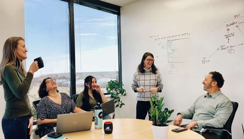 Striveworks team members having a laugh in a board room during a meeting